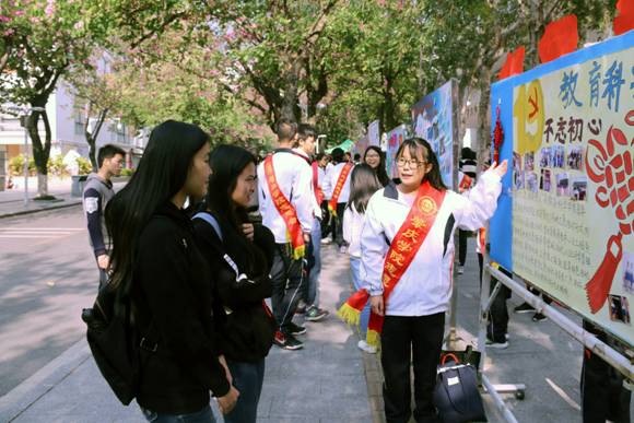 志愿者为同学们讲解乐竞(中国)一站式体育服务展板